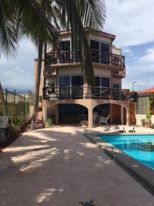 a building with a swimming pool in front of a house at Casa de la Tortuga in Zihuatanejo