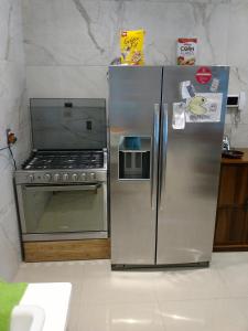 a kitchen with a stove and a stainless steel refrigerator at Casa Zen in Pachuca de Soto