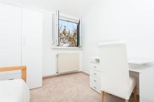 a white bedroom with a window and a desk at Apartment Relax in Fažana