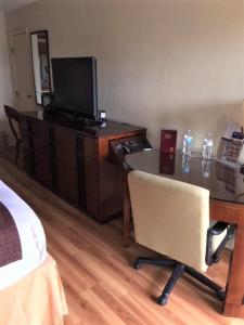 Zimmer mit einem Schreibtisch, einem TV und einem Stuhl in der Unterkunft Royal Inn in Sparta