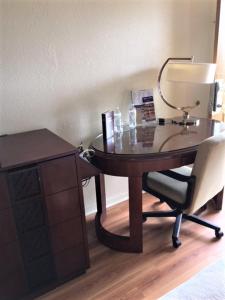 mesa de madera con silla y escritorio con lámpara en Royal Inn, en Sparta