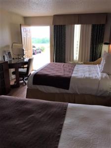 a hotel room with two beds and a desk and a window at Royal Inn in Sparta