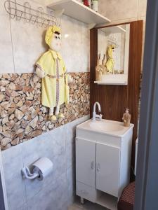 une salle de bain avec une statue de femme à côté d'un lavabo dans l'établissement Apartamento no Centro de Canela, à Canela 27 autres photos