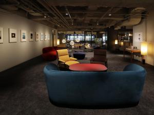a living room with a blue couch and chairs at THE KNOT TOKYO Shinjuku in Tokyo