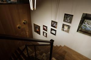 a hallway with pictures on a wall with a staircase at THE KNOT TOKYO Shinjuku in Tokyo