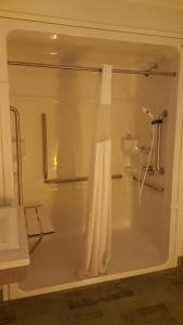 a bathroom with a bath tub with a shower curtain at Centennial Motel in Kindersley