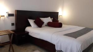 um quarto com uma cama grande e lençóis brancos em Amazing Villa em Matara