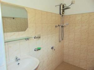 Un baño con lavabo y ducha con espejo. en Sampalthivu Beach Villa, en Trincomalee