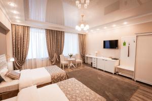 pokój hotelowy z 2 łóżkami i telewizorem w obiekcie Hotel Ankor w mieście Błagowieszczeńsk