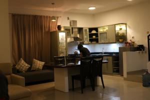 a kitchen and living room with a table and a couch at NZHome Residence in Karawang