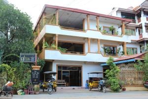 a building with motorcycles parked in front of it at Seven Candles Guesthouse in Siem Reap