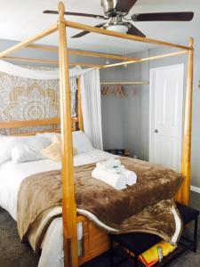 um quarto com uma cama de dossel e toalhas em Boho Chic Beach Suite em San Diego