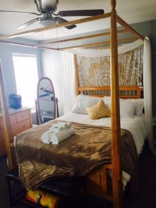 sypialnia z łóżkiem z baldachimem i pluszakiem w obiekcie Boho Chic Beach Suite w mieście San Diego