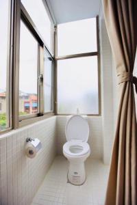 a bathroom with a toilet and a window at Mayhow Donghe in Donghe