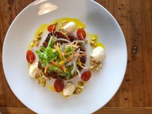 a white plate with food on a wooden table at Waitaki Braids in Kurow