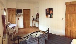 クローリーにあるTanglewood Gatwick Bed & Breakfastのベッドルーム1室(ベッド1台、テーブル付)