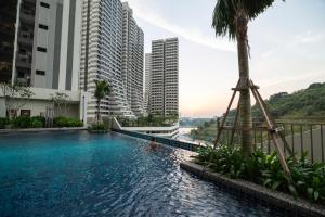 a swimming pool in the middle of a city with tall buildings at Ramada Meridin Johor Bahru in Nusajaya