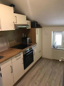 a kitchen with white cabinets and a black oven at Haus Annerl Ferienwohnung mit 2 Schlafzimmern in Inzell