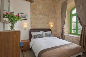 a bedroom with a bed and a vase of flowers at Olive Heleni Hotel in Jerusalem