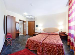 a hotel room with a bed with a red bedspread at Antico Albergo Madonna in Legnano