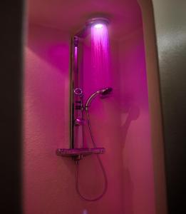 a bathroom with a shower with a pink light at B&B Droomboot in Oudenburg
