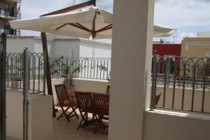 a patio with chairs and an umbrella on a balcony at Residence La Corte in Porto Cesareo