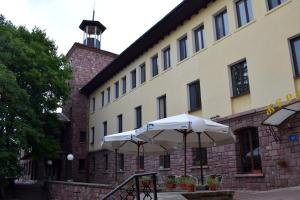 a building with two white umbrellas in front of it at Hotel Jeravna in Bankya