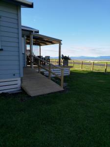 une terrasse couverte d'une maison avec une terrasse en bois dans l'établissement Sea Urchin Cottage, à Miranda