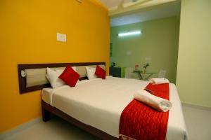 a bedroom with a large bed with red and white pillows at Sumi Palace Annexure in Vallam