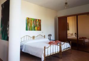 トルトレート・リドにあるAl profumo d'ulivoのベッドルーム1室(ベッド1台付)が備わります。壁には絵画が飾られています。