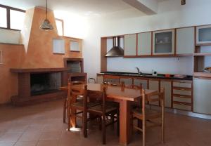 トルトレート・リドにあるAl profumo d'ulivoのキッチン(テーブル、椅子、暖炉付)