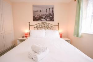 a bedroom with a white bed with towels on it at Town or Country - Captains Place in Southampton