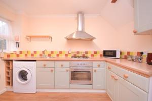 a kitchen with white cabinets and a washer and dryer at Town or Country - Captains Place in Southampton