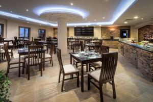 um restaurante com mesas e cadeiras de madeira e um bar em Aura Resort Sidi Abd El Rahman El Alamein em Sīdī ‘Abd ar Raḩmān