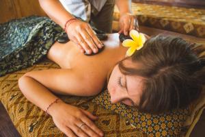 a woman getting a massage from a therapist at De Klumpu Bali Eco Tradi Stay in Bangli