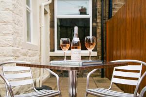 a table with two wine glasses and a bottle of wine at BELLE VUE - SKIPTON in Skipton