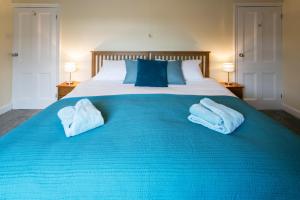 a blue bed with two towels on top of it at BELLE VUE - SKIPTON in Skipton