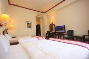 Postel nebo postele na pokoji v ubytování East Commercial Affairs Hotel