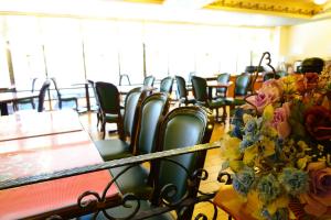 a row of chairs and tables in a room with flowers at East Commercial Affairs Hotel in Luodong