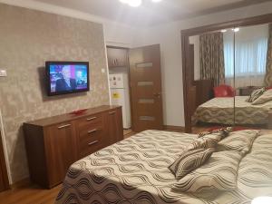 a hotel room with two beds and a flat screen tv at Casa Mirage in Craiova