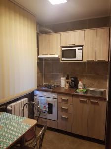 a kitchen with a stove and a microwave and a table at Casa Mirage in Craiova