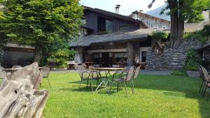 a table and chairs in front of a house at La Brace in Forcola