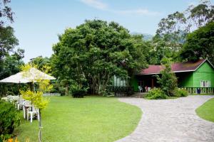 a green house with a table and chairs in a yard at Hemerocallis Country House in Nanzhuang