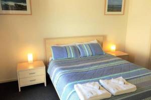 a bedroom with a bed with two towels on it at Bayview Beach House Apartment No 1 in Kingscote