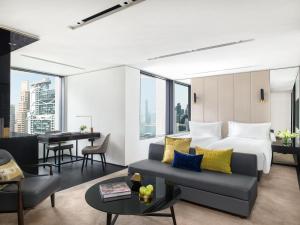 una camera d'albergo con letto e divano di The Murray, Hong Kong, a Niccolo Hotel a Hong Kong