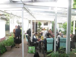 a group of people sitting at tables under a pergola at Hotel Attaché in Raunheim
