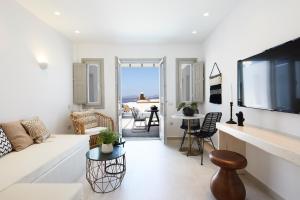 a living room with a white couch and a tv at Phos The Boutique in Akrotiri