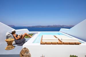 a woman sitting on the roof of a house at Phos The Boutique in Akrotiri