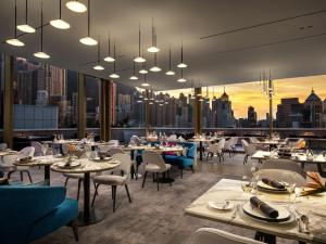um restaurante com mesas e cadeiras e vista para a cidade em The Murray, Hong Kong, a Niccolo Hotel em Hong Kong