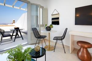 a living room with chairs and a table and a tv at Phos The Boutique in Akrotiri